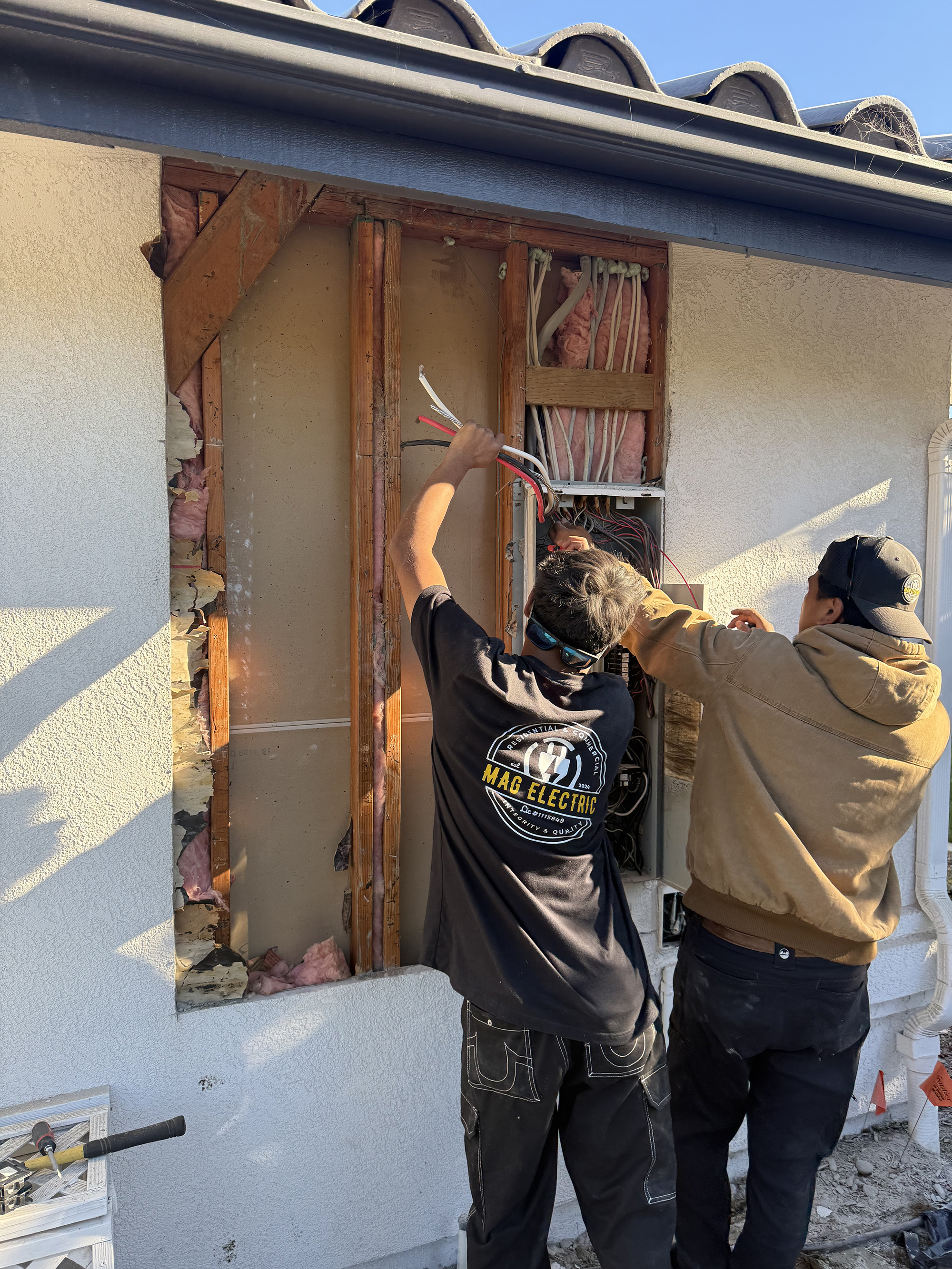 Electricians upgrading residential electrical panel exterior wall SLO County CA MAG Electric licensed
